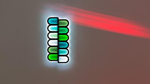 Artwork featuring a vertical line of half-oval shapes in green, blue and white, pushed against each other.