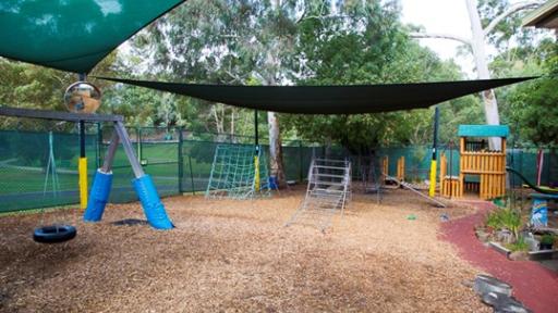 Shadecloth covers an outdoor play area with barkchips