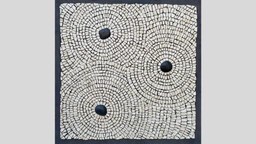 An artwork featuring a mosaic with three black rounded stones making a triangle on a surface and beige square mosaic tiles rippling out from them to meet each other