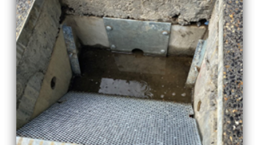 a photo of the inside of the control pit that shows the trash grate and orifice plate