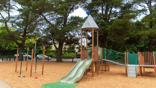 Playground showing a timber unit with slide, walkway and climbing stairs