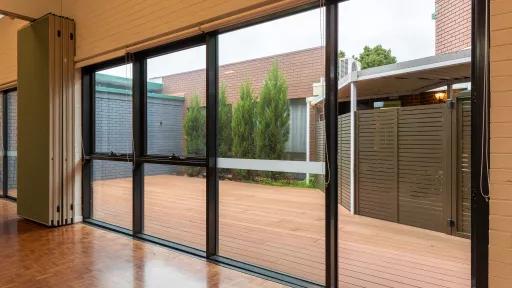 A small outdoor patio area surrounded by a brick wall, trees and a wooden fence