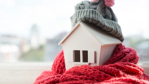 small-size model of a house wrapped in a wool scarf and beanie