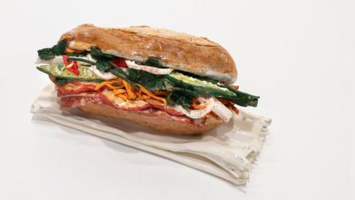 A baguette roll with salad filling on a blank background