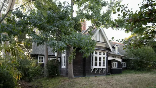 large historic weatherboard house surrounded by trees