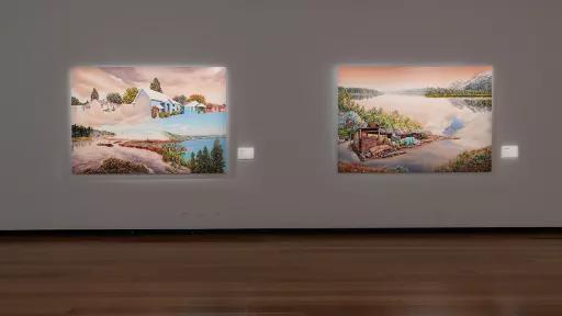 Photograph of large landscape paintings hanging in a gallery