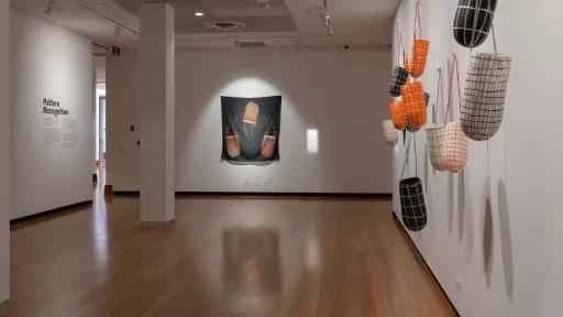 Photo of hanging paper sculptures and silk hanging in a gallery.