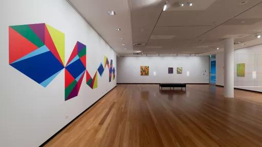 Photo of mixed media artwork and paintings in a gallery.