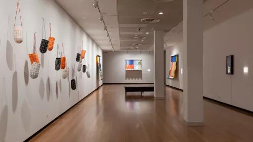 Photo of hanging paper sculptures and mixed media work in a gallery.
