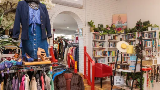 A store with clothes racks, a mannequin and shelves of books