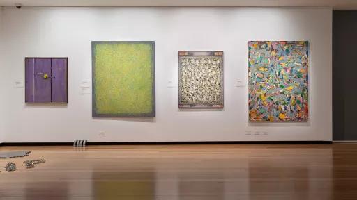 Installation view of abstract paintings hanging in a gallery