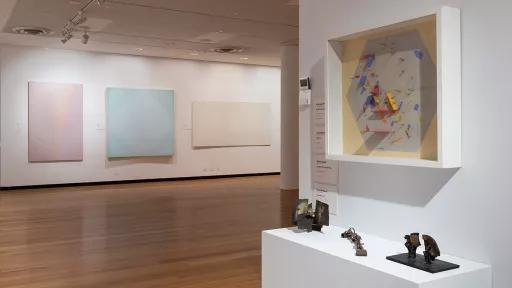 Installation view of abstract paintings hanging in a gallery