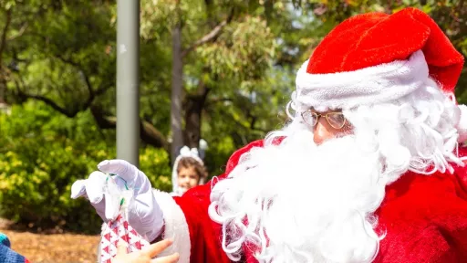 Santa in his red and white outfit handing out lolly bags