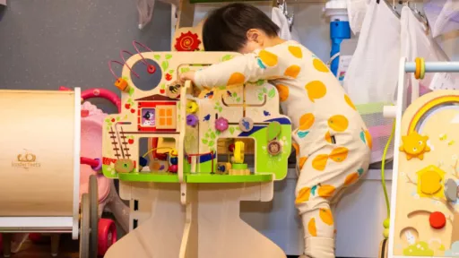 Small child plays with colourful wooden toy