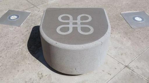 a smooth stone, curved at the front and flat on the top. There is a large infinity symbol carved into the top