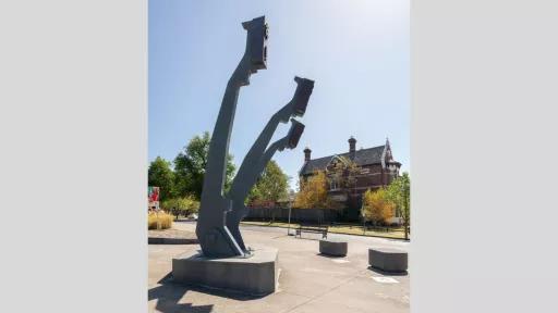 a view from the side of a large sculpture. The sculpture features three arms that mimic the arms of a typewriter