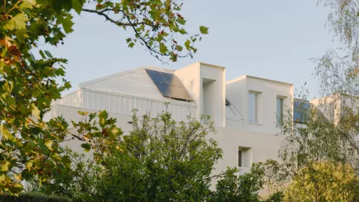 The top floor of a white house surrounded by trees