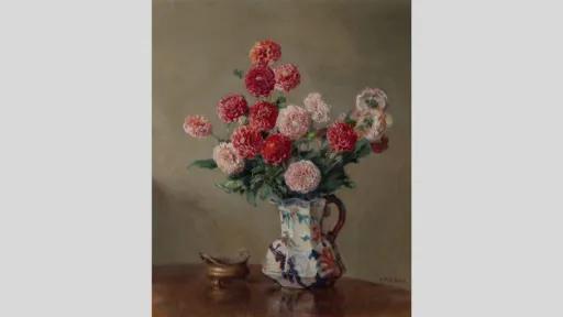 A still life painting of pink and red dahlias arranged in a floral jug sitting on a wooden table.