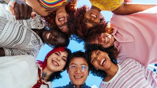 A group of young people standing in a circle looking down at the camera