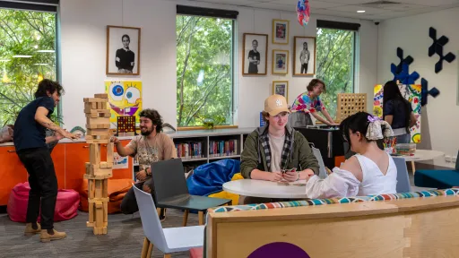 Teenagers playing cards in a colourful room