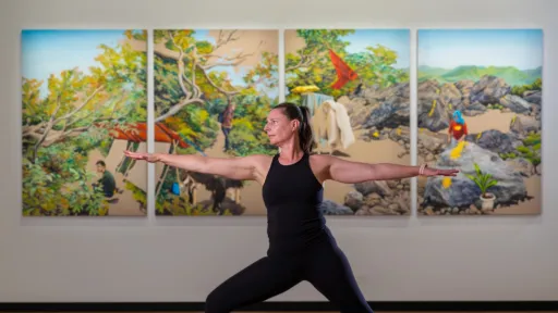 A woman stands in yoga pose in an art gallery