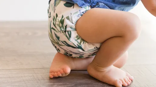 a baby wearing a reusable cloth nappy crouching