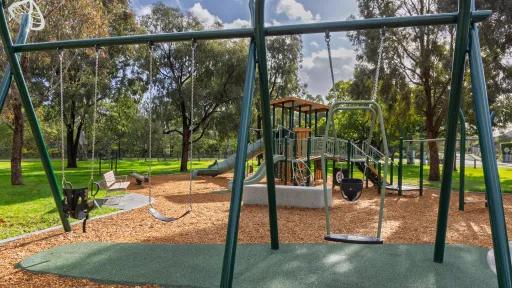 A series of swings at different heights in a playground