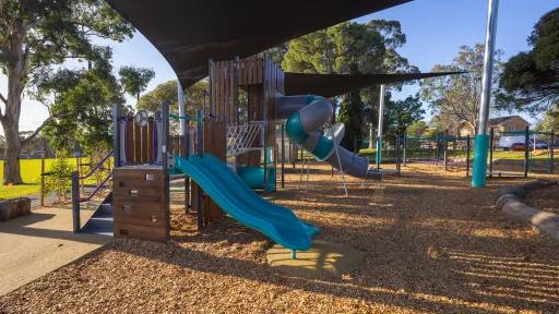 A small slippery dip and a larger, tubular, enclosed slide in a playground