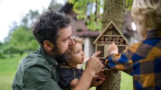 A family outside looking at a bird house.