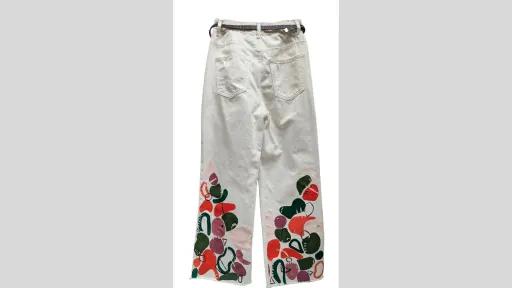Back of a pair of white denim pants with a brown belt looped around its waist. End of pants are painted with graphic shapes in green, pink, red and purple. 