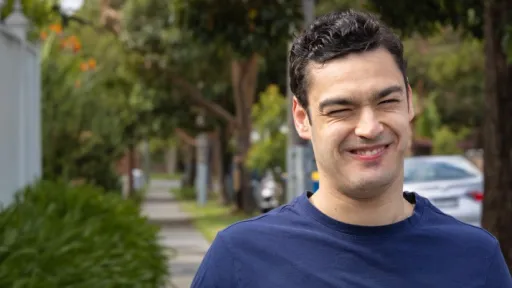 A smiling young man on a neighbourhood street