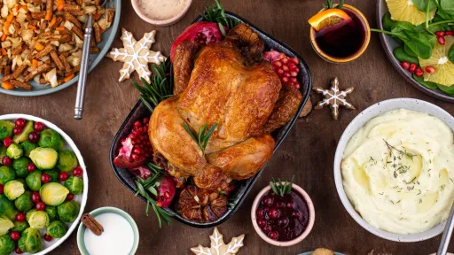 Dishes of turkey, salads and potatoes on table with Christmas decorations