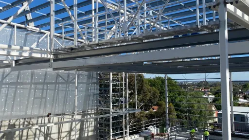 A building with exposed steel frames and a pool area