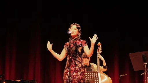 A woman in a cheongsam sings on stage