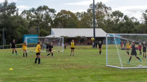A soccer pitch with temporary goals set up at either end. A youth match is being played.