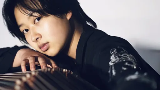 a musician looking down the length of a guzheng.