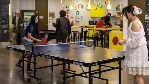 Teenagers playing table tennis indoors
