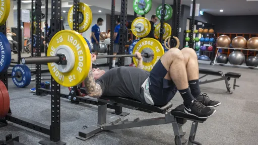 a man bench presses a heavy barbell 