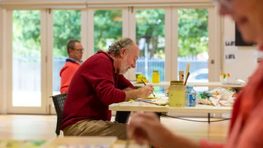 A man doing a craft activity at a community centre