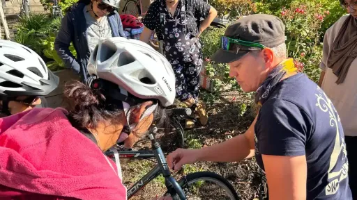 Women in bike helmets looking at a mountain bike