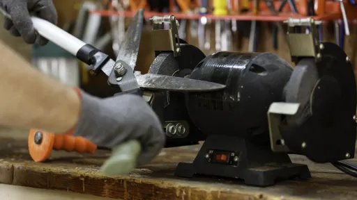 A pair of hedge trimmers being sharpened on a lathe.