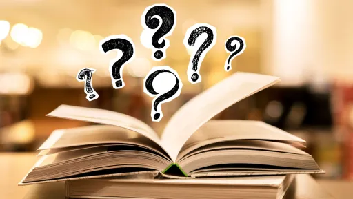 An open book lies flat on a table with floating question marks hovering above