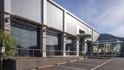 Grey metal-clad building in car park