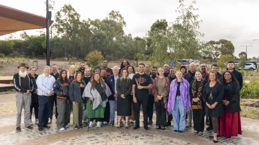 A group of about 30 Aboriginal people standing together at a gathering place.