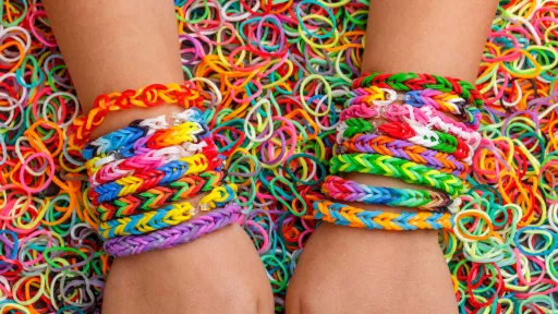 Someone wearing loom bands on their wrists surrounded by loom bands