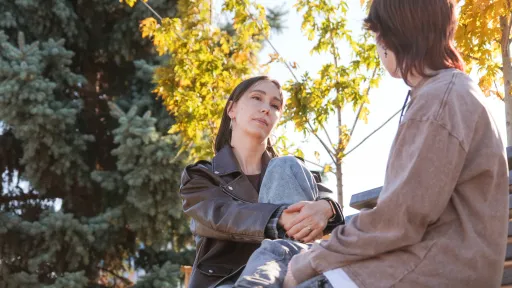 Two women talk to each other in a park