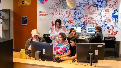 Young people sitting at a computer working together.
