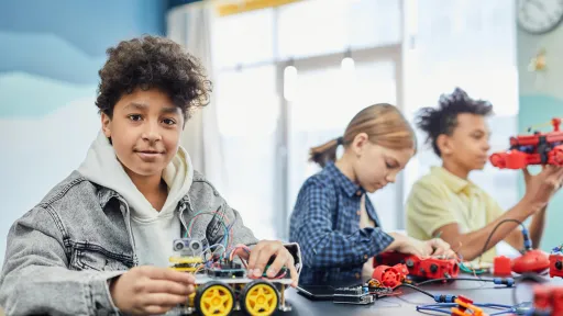 Three children are constructing lego robots