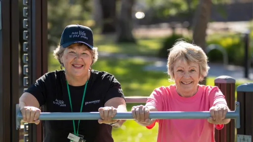 Two women using exercise equipment.