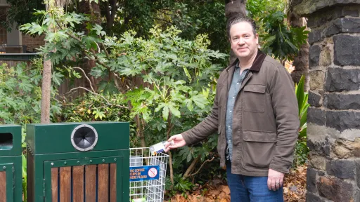 Person putting an item in a container deposit scheme bin basket